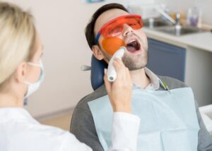 Man receiving Laser Treatment for his tooth from Dentist in Scottsdale, AZ